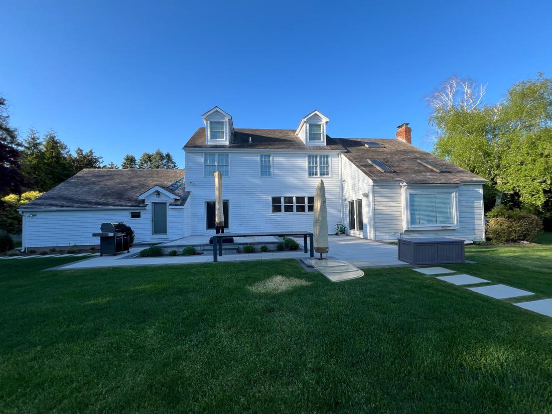 White colonial home and backyard