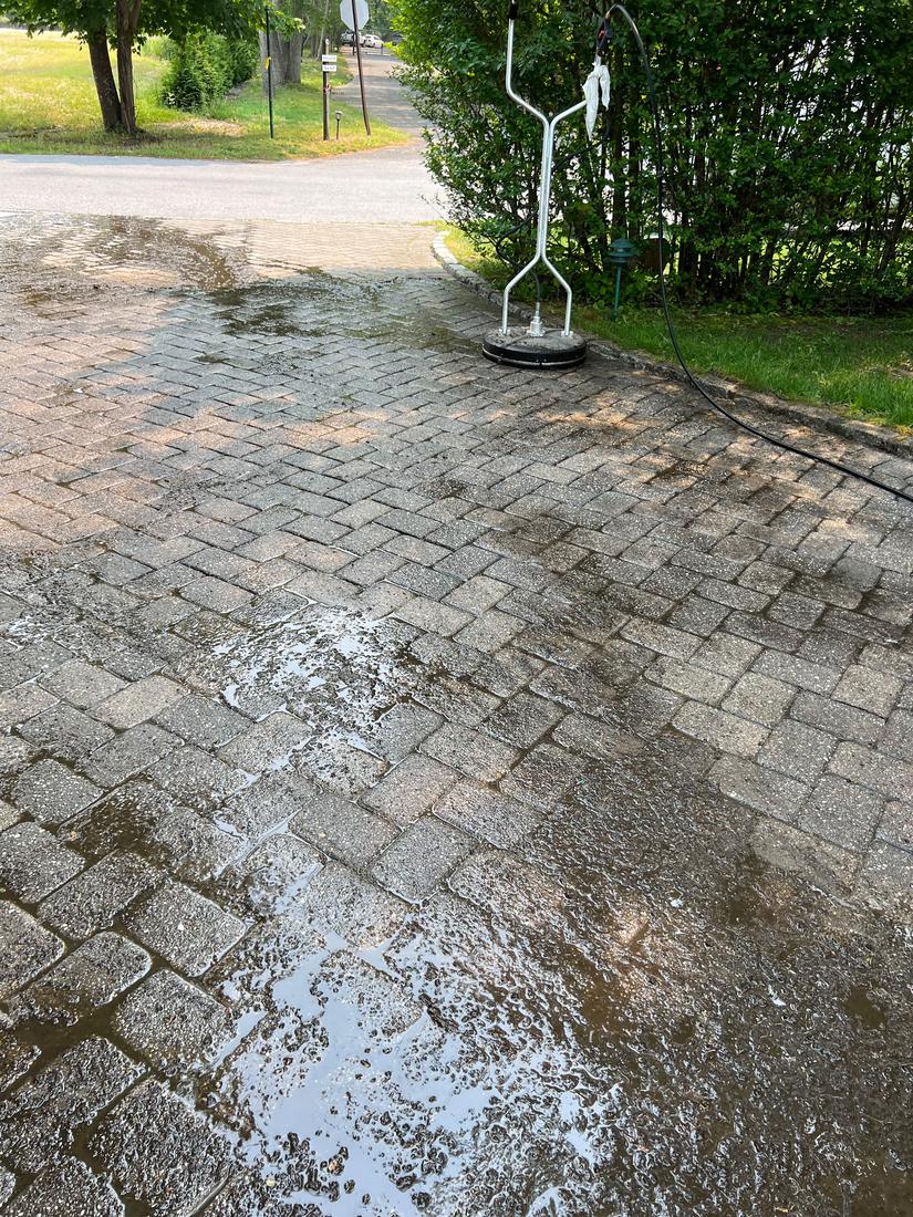 Pavers being power washed, clean section next to dirty section